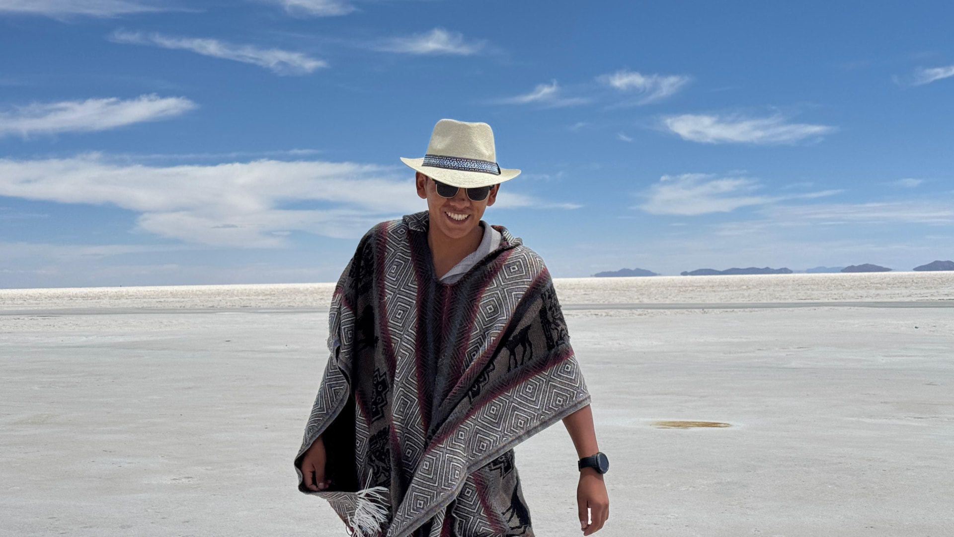 Viajante de poncho andino e chapéu no Salar de Uyuni